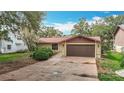 A well-maintained single-story home with a brown roof, two-car garage, and established landscaping at 4420 Marine Pkwy, New Port Richey, FL 34652