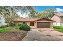 Inviting single-story home with a brown roof, two-car garage, and attractive front yard shrubbery at 4420 Marine Pkwy, New Port Richey, FL 34652