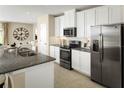 Stylish kitchen with stainless steel appliances, granite countertops, and bright white cabinetry at 4511 Spire Run, Lakewood Ranch, FL 34211