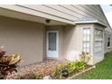 Inviting front porch features tiled flooring, a white front door, and mature landscaping at 4837 Boonesboro Ct, New Port Richey, FL 34655