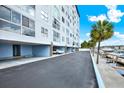Exterior of waterfront condo building with covered parking, boat docks, and palm trees, providing resort-style living at 4939 Floramar Ter # 204, New Port Richey, FL 34652