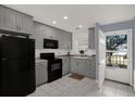 Well-lit kitchen featuring stainless steel appliances, gray cabinets, and granite countertops, offering a blend of style and functionality at 4939 Floramar Ter # 204, New Port Richey, FL 34652