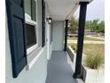 Exterior porch with support beams and blue shutters framing a large window at 5023 Queen Palm Dr, New Port Richey, FL 34652