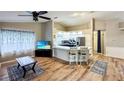 Open-concept kitchen boasts white cabinets, a breakfast bar, and stainless steel appliances adjacent to the living area at 5152 Panther Dr, Spring Hill, FL 34607