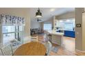 Bright kitchen with white and blue cabinets, a bar top counter and stainless steel appliances in an open floor plan at 5152 Panther Dr, Spring Hill, FL 34607