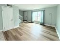Open-concept living room with light wood flooring, a large window, and light blue walls at 5713 Townhouse Dr # 5713, New Port Richey, FL 34652