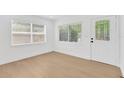 Bright room with pristine white walls, stylish door and light hardwood floors with natural light at 5753 2Nd N Ave, St Petersburg, FL 33710
