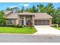 Inviting home with well-manicured lawn, screened garage and a welcoming front entrance at 7367 Willow Brook Dr, Spring Hill, FL 34606