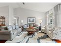 Bright living room with vaulted ceilings, comfortable seating, and a large window at 7367 Willow Brook Dr, Spring Hill, FL 34606