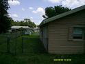 View of the backyard showcasing a chain link fence for privacy and a well-maintained lawn at 7419 E Comanche Ave, Tampa, FL 33610