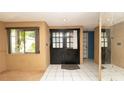 Inviting foyer with tile flooring, decorative mirror and double door entrance at 7501 Woodbox Row, Hudson, FL 34667