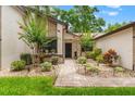 Charming single-story home with a well-manicured lawn, garden beds, and a brick pathway leading to the front entrance at 7512 Heather Walk Dr, Weeki Wachee, FL 34613