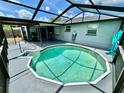 Screened in backyard featuring a round pool with a covered outdoor seating area at 7719 Gaston Dr, Port Richey, FL 34668