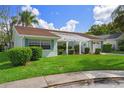 Charming single-story home featuring a well-maintained lawn, blue trim, and a pergola-covered entrance at 8021 Wildflower Row, Hudson, FL 34667