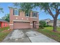 Two-story home featuring a two-car garage, well-maintained lawn and exterior at 9527 Southern Charm Cir, Brooksville, FL 34613