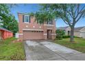 Two-story home featuring a two-car garage, well-maintained lawn and exterior at 9527 Southern Charm Cir, Brooksville, FL 34613