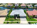 Aerial view of the home showcasing its well-manicured lawn and surrounding neighborhood on the water at 9810 Compass Point Way, Tampa, FL 33615