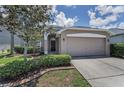 Charming single-Gathering home features a well-manicured lawn and a two-car garage under a bright sunny sky at 10344 Tecoma Dr, Trinity, FL 34655