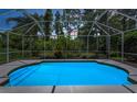 Inviting in-ground screened pool offers a refreshing retreat surrounded by lush greenery and mature trees at 10344 Tecoma Dr, Trinity, FL 34655