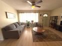 Inviting living room featuring a ceiling fan, comfortable seating, and natural light, great for relaxation at 10431 Syringa Ct, Port Richey, FL 34668