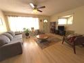 Inviting living room featuring a ceiling fan, comfortable seating, and natural light, great for relaxation at 10431 Syringa Ct, Port Richey, FL 34668