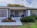 Inviting screened front porch with comfortable seating and well-maintained landscaping at 11141 Sandtrap Dr # 11141, Port Richey, FL 34668
