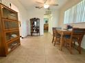 Open dining area with tiled floors, wooden table and chairs, and display cabinet at 11911 Bayonet Ln, New Port Richey, FL 34654