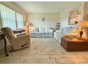 Bright living room with tile floors, comfortable seating, and lots of light from large window at 11911 Bayonet Ln, New Port Richey, FL 34654