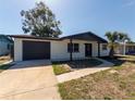 Inviting single-story home featuring a fresh exterior, dark trim, and a convenient attached garage at 1249 Honor Dr, Holiday, FL 34690