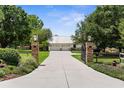 Long concrete driveway leading to a detached three-car garage with an iron gate at 1253 Culbreath Rd, Brooksville, FL 34602