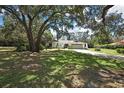 Beautiful single-story home with a well-manicured lawn and mature trees offering shade and curb appeal at 12722 Oak Tree Dr, Hudson, FL 34667