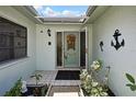 Inviting front door entrance with decorative wreath and well-maintained tiled entryway, enhanced by lush plants and greenery at 12722 Oak Tree Dr, Hudson, FL 34667