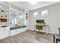 Well-lit home office featuring built-in shelves, a bench, and a modern desk at 12854 Rangeland Blvd, Odessa, FL 33556