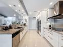 Modern kitchen features granite countertops, stainless steel appliances, tile flooring, and ample cabinet space at 13627 Glaze Brook Dr, Hudson, FL 34667