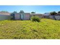Unkept backyard featuring a grass lawn at 13730 Coco Ave, Hudson, FL 34667