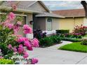 Beautiful landscaping surrounds the walkway to this lovely home with an arched window at 18520 Hidden Pines Way, Hudson, FL 34667