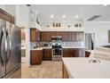 Well-lit kitchen featuring stainless steel appliances, tiled backsplash, and ample cabinet space at 18520 Hidden Pines Way, Hudson, FL 34667