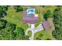 Aerial view of the home, featuring a pool, spacious backyard, and detached garage at 21000 Exeter Ct, Brooksville, FL 34601