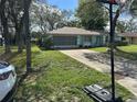 Home with a driveway and a well-manicured lawn, complemented by shade trees at 2158 Clayton Ave, Spring Hill, FL 34609