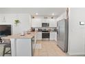 Bright kitchen with stainless steel appliances, granite countertops and white cabinetry at 33592 Barberry Leaf Way, Wesley Chapel, FL 33543