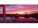 Stunning sunset view from the porch overlooking the canal with boats docked and a vibrant sky at 3546 Flamingo Blvd, Hernando Beach, FL 34607