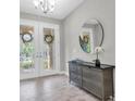 Elegant entryway with stylish console table, decorative mirror, and grand double doors with decorative glass at 3767 Dragonfly Trl, Odessa, FL 33556