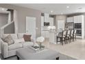 Inviting living room and kitchen featuring a modern design, granite countertops, stainless steel appliances, and bar seating at 4625 Arden Way, Lakewood Ranch, FL 34211
