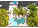 Aerial view of backyard featuring a free form pool, patio with lounge seating, and private dock at 4917 Marlin Dr, New Port Richey, FL 34652