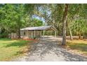 Exterior shot of the property's outbuilding with an attached carport and gravel driveway at 5487 Valley View Dr, Brooksville, FL 34601