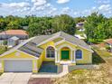 Inviting yellow single-story home showcasing a green front door, arched windows, and well-maintained lawn at 6028 Dorset Rd, Spring Hill, FL 34608