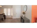 A bright entryway featuring wood-look flooring, an accent table, and a decorative mirror at 6309 Covewood Dr, Spring Hill, FL 34609