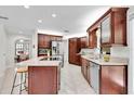 Kitchen with stainless steel appliances, granite countertops, a center island with a cooktop, and ample storage space at 6454 Summerfield Loop, Trinity, FL 34655