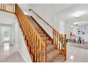 Carpeted staircase with wooden handrails, leading to the upper level of the home bathed in natural light at 6454 Summerfield Loop, Trinity, FL 34655