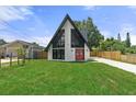 Charming A-frame house with a unique design, highlighted by striking black trim and expansive lawn at 7422 New York Ave, Hudson, FL 34667